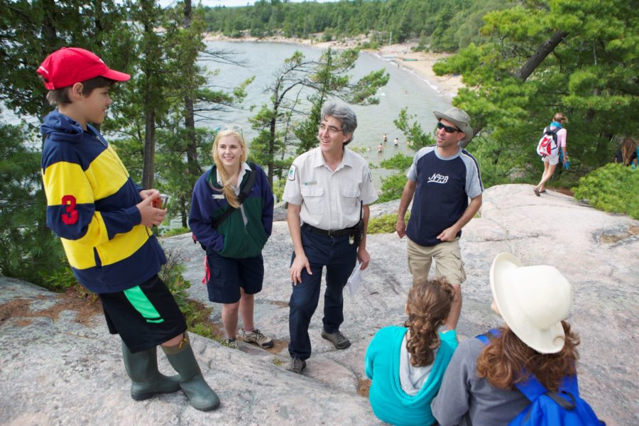 At the end of a guided hike at Killbear Provincial Park staff members and visitors chat.