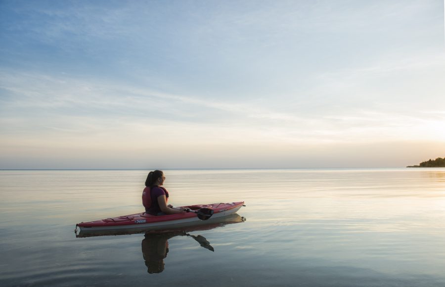 woman paddling on quiet lake