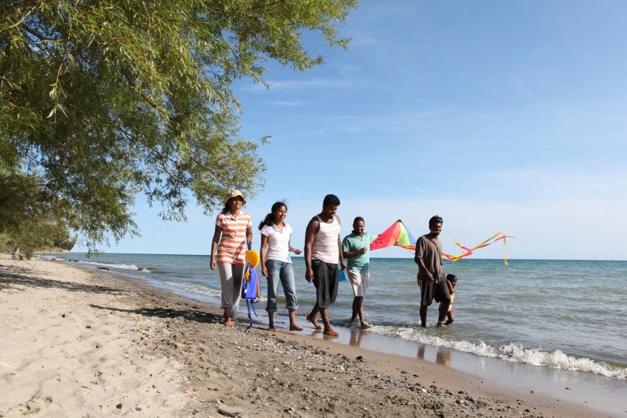 Une famille marchant sur la plage de sable 