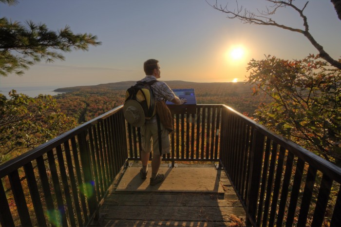 man at edmund fitzgerald lookout with sun setting