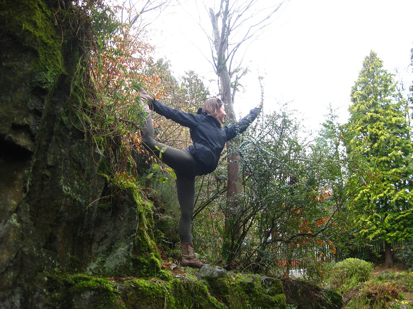 Une femme pratique une posture de yoga sur une roche