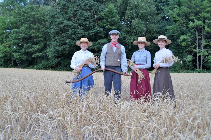 Staff wearing period costumes while standing in field