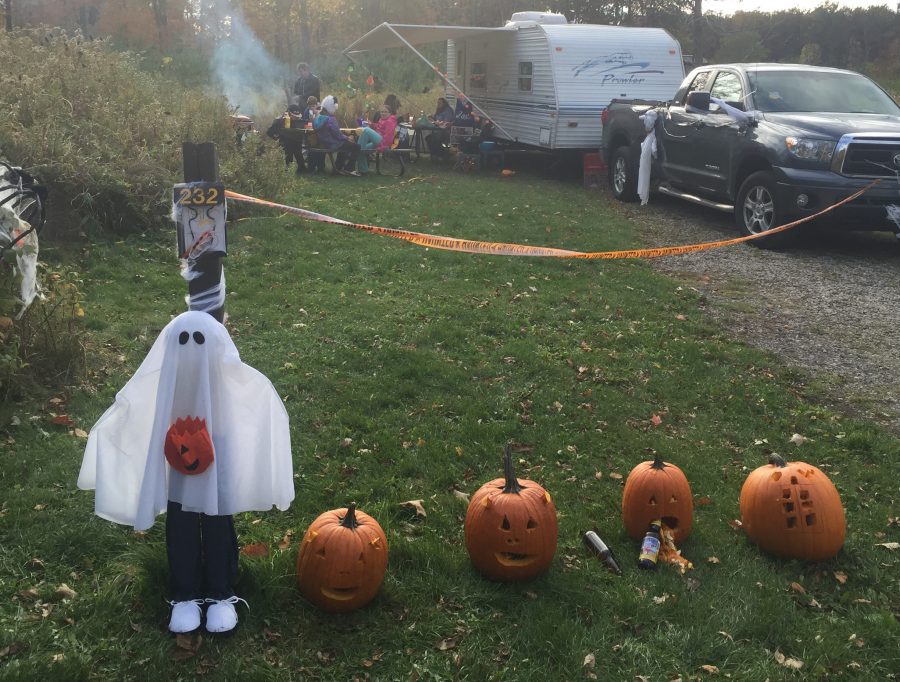 campsite decorated and family having supper getting ready for camper halloween - trick or treating.