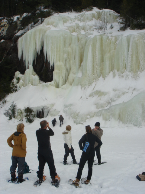 snowshoers looking at ice formation