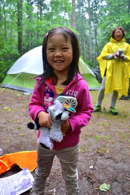 girl holding stuffed animal on campsite