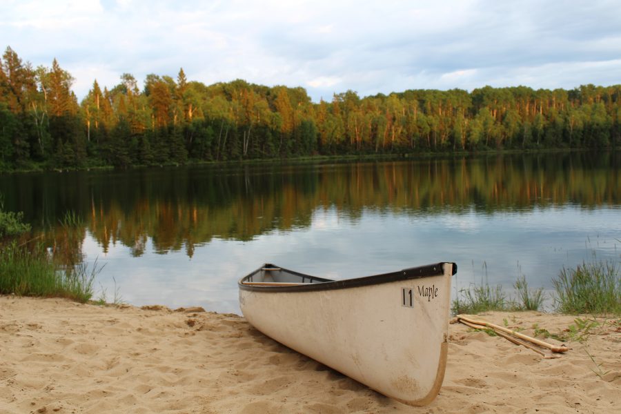 canoe beached beside lake