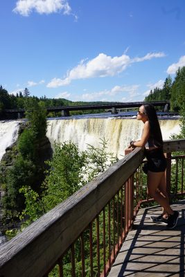 woman looking out at falls from boardwalk