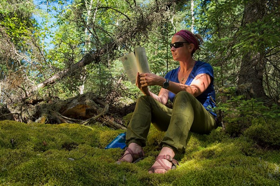 woman reading on moss