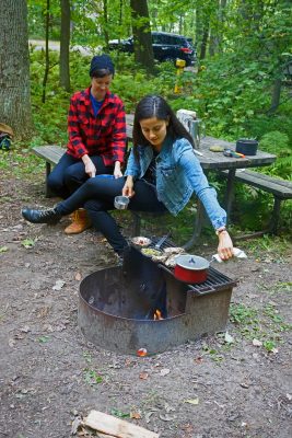 women cooking over campfire