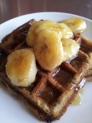 Close up of waffles with banana on top. 