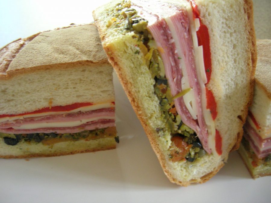 Close up of Muffuletta sandwich with meat, cheese, and vegetables. 