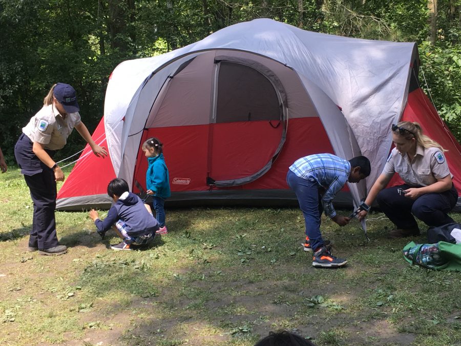 Learn to Camp leaders help kids pitch a tent. 