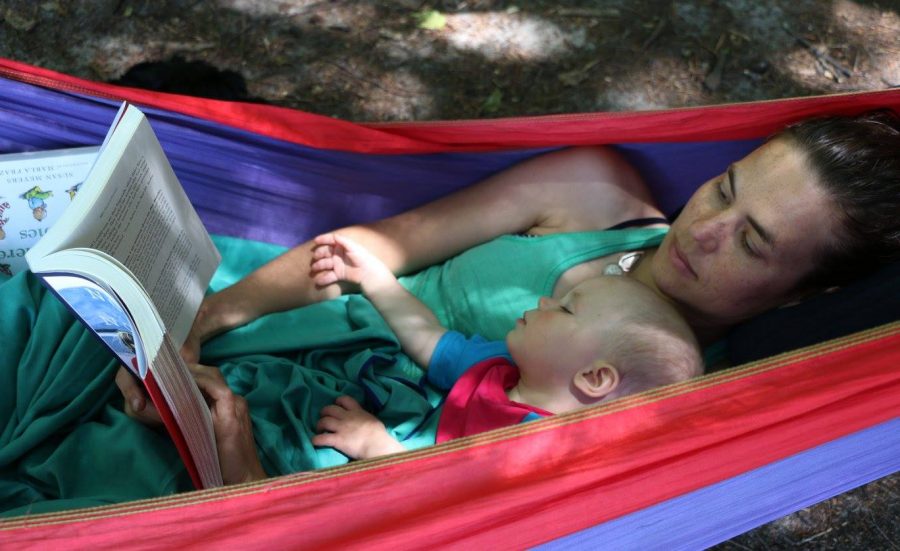 Mom reads story to baby in hammock