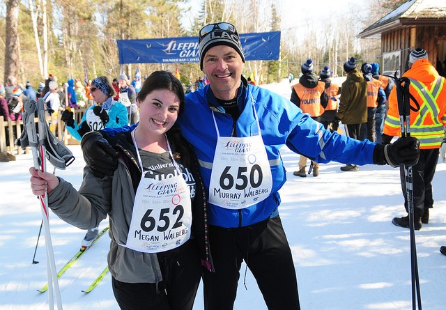 Un père et sa fille en tenues de ski