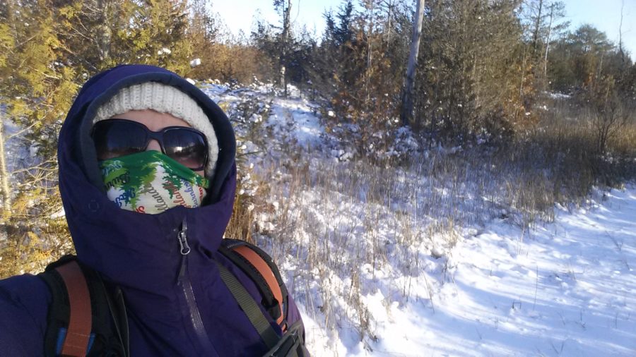 ecologist standing on winter trail, all bundled up