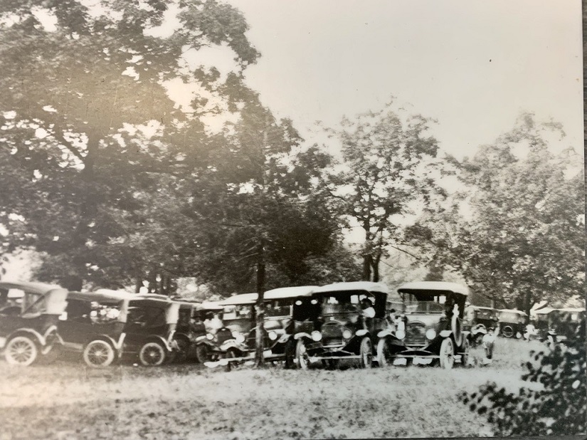 Historical photo of cars on a field. 
