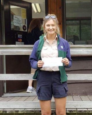 Student holds envelope outside of park office