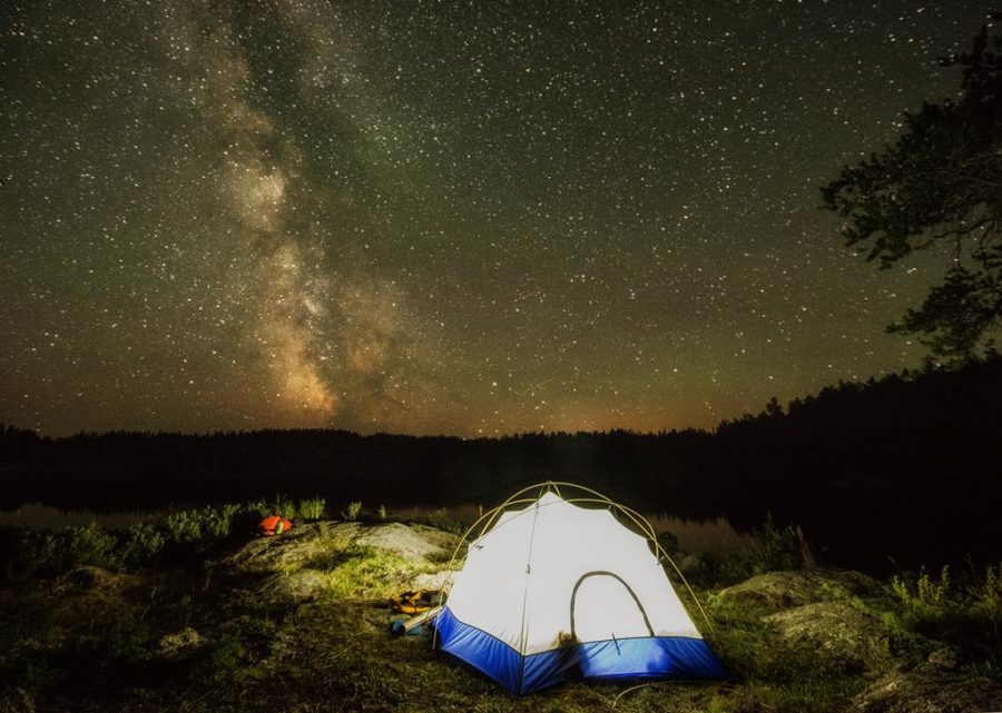 Une tente éclairée sous un ciel étoilé