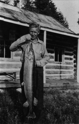 Black and white photo of man holding a fish