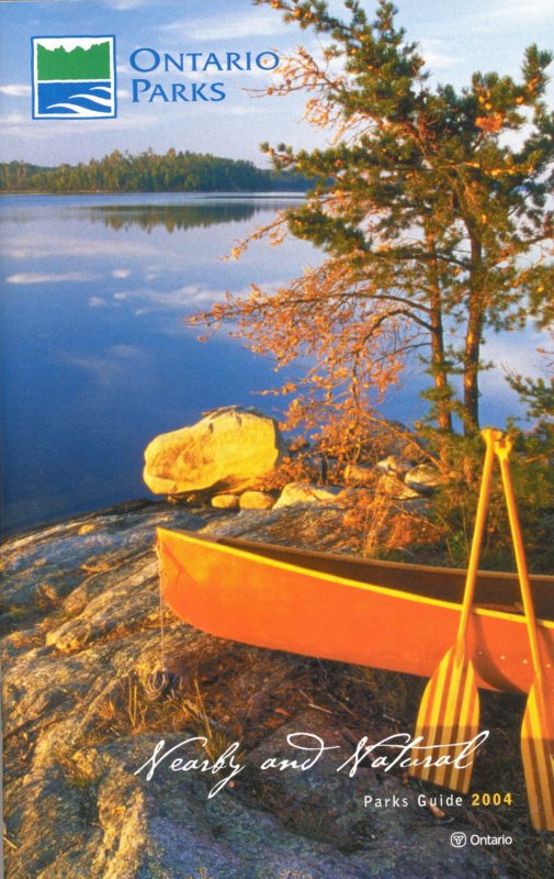 booklet with canoe on rocky outcrop by lake