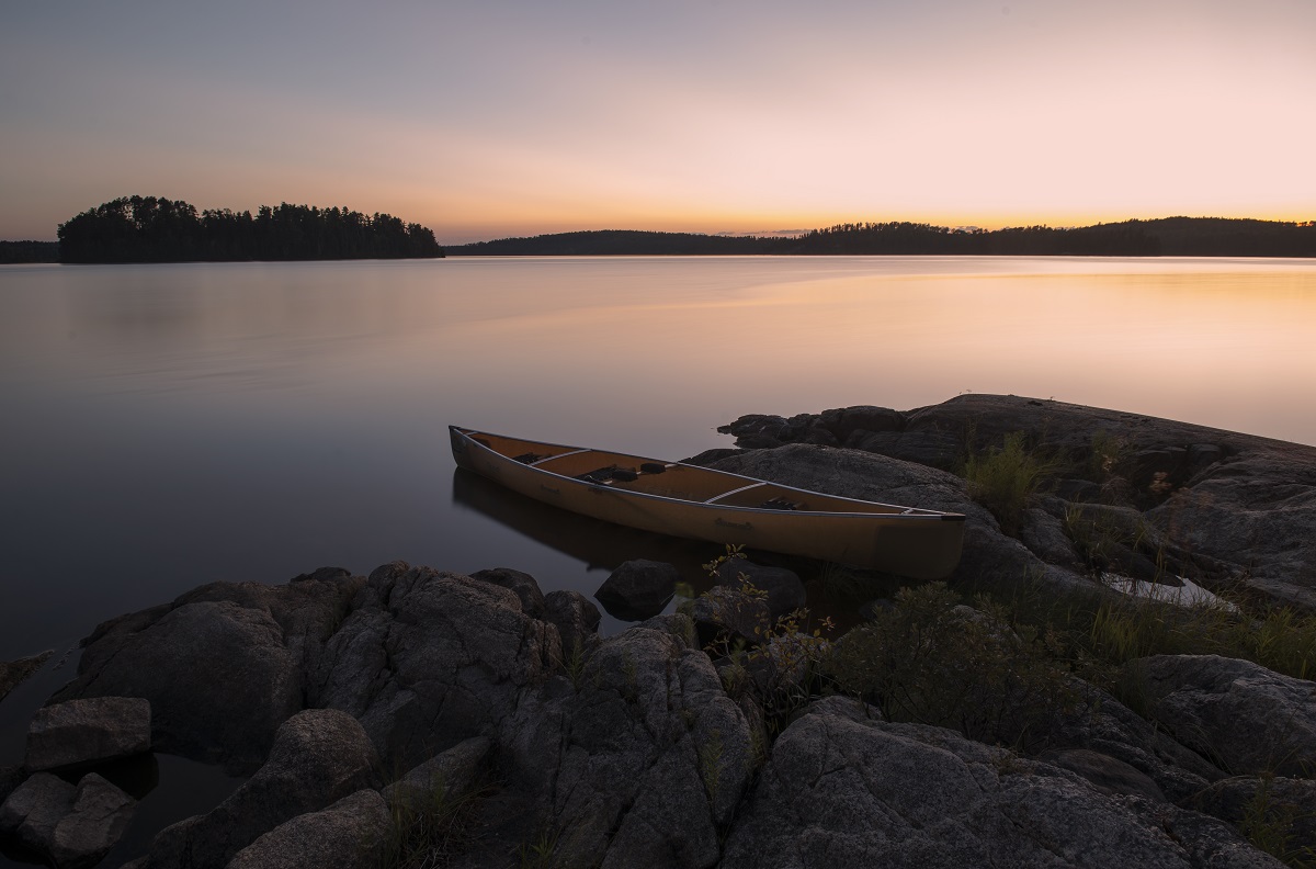 Un canot sur la rive au coucher du soleil