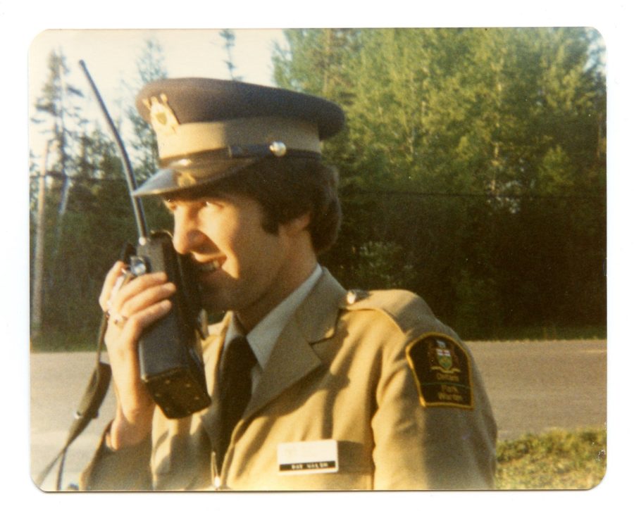 Park Warden fro the 70's on a sunny day speaking into a two-way radio