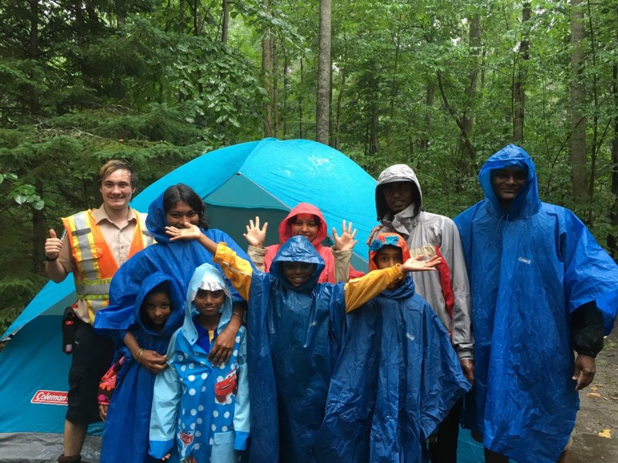 10 campers in rain gear posing for the camera with big smiles
