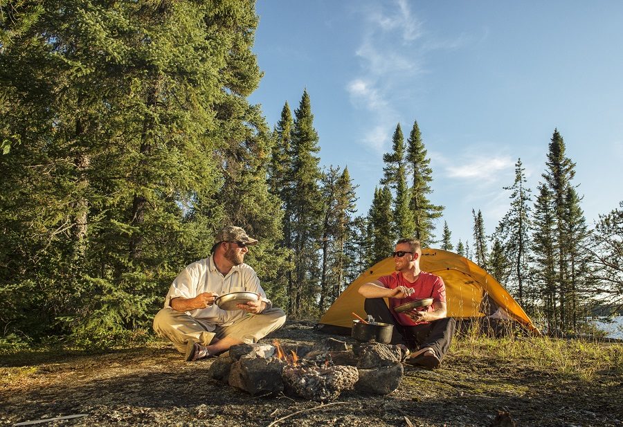 Deux hommes se reposent à un emplacement de camping en arrière-pays