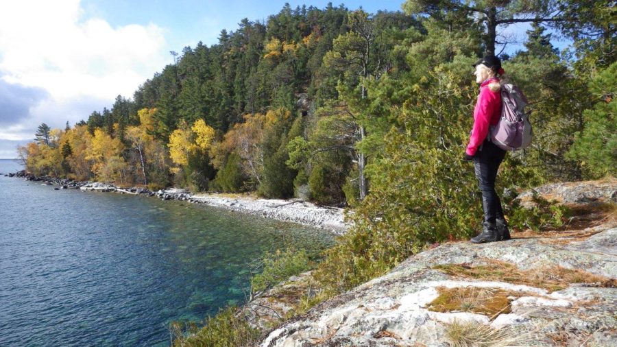 Hiker looking out at Lake Superior from the north shore in the early fall