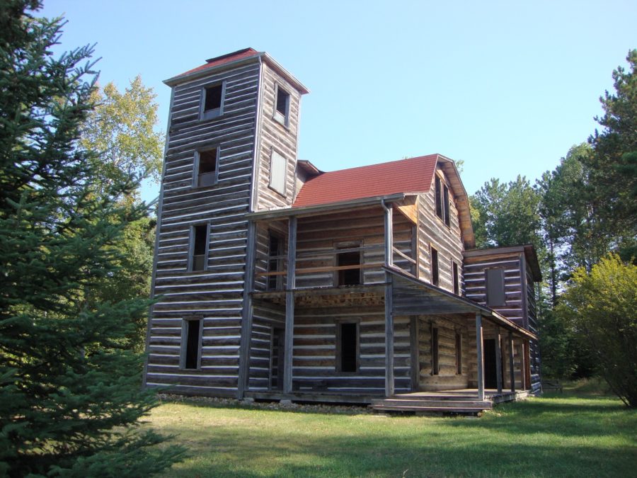 Grande cabine en bois avec une tour de quatre étages et un toit rouge.