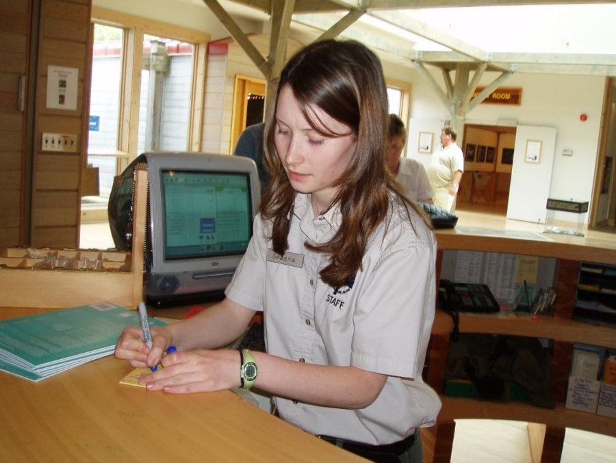 Young girl with brown hair behind a desk at a park Visitor Centre