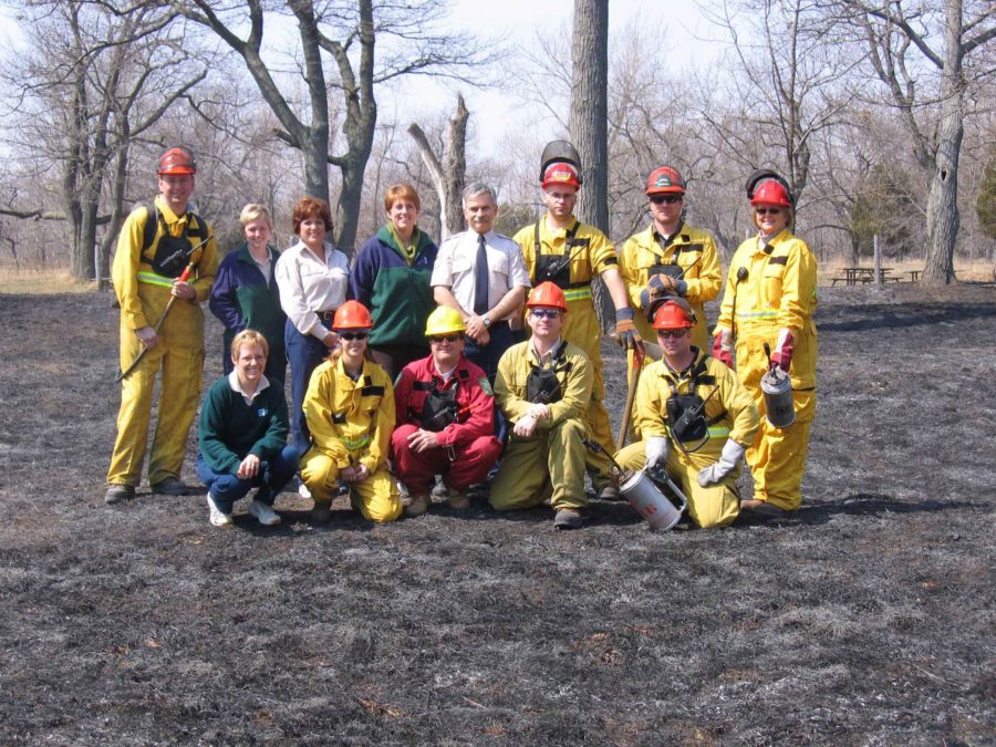 Group of people posing on burned grey grass
