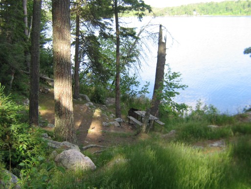 Emplacement de camping ombragé au bord de l’eau, à flanc de colline.