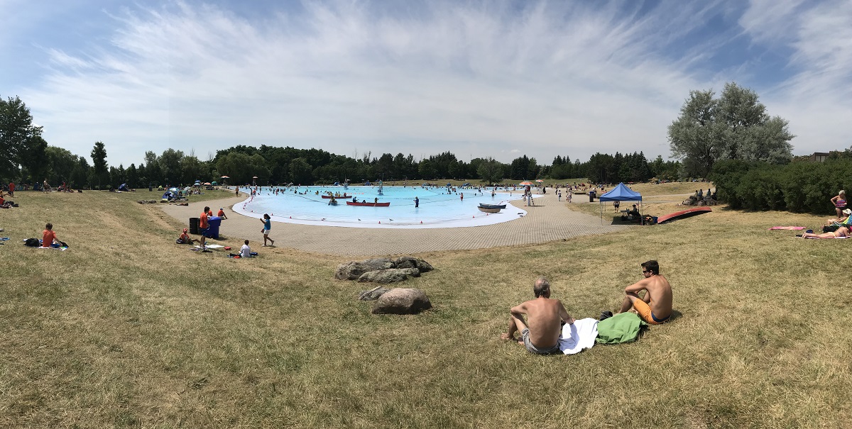 Panorama of the a large pool surrounded by brown grass