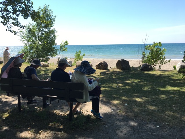 Group sits on bench overlooking water