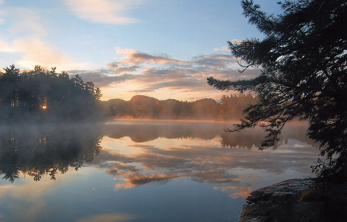 Mist rising from a lake with a pink and blue sky in the backgrounf