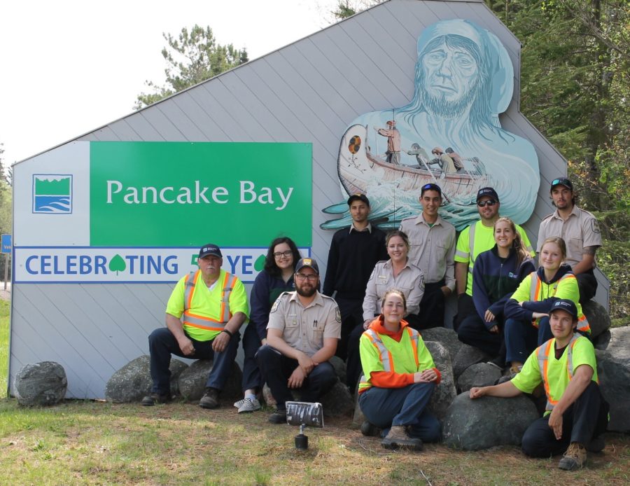 Le personnel de Pancake Bay devant l’enseigne du parc