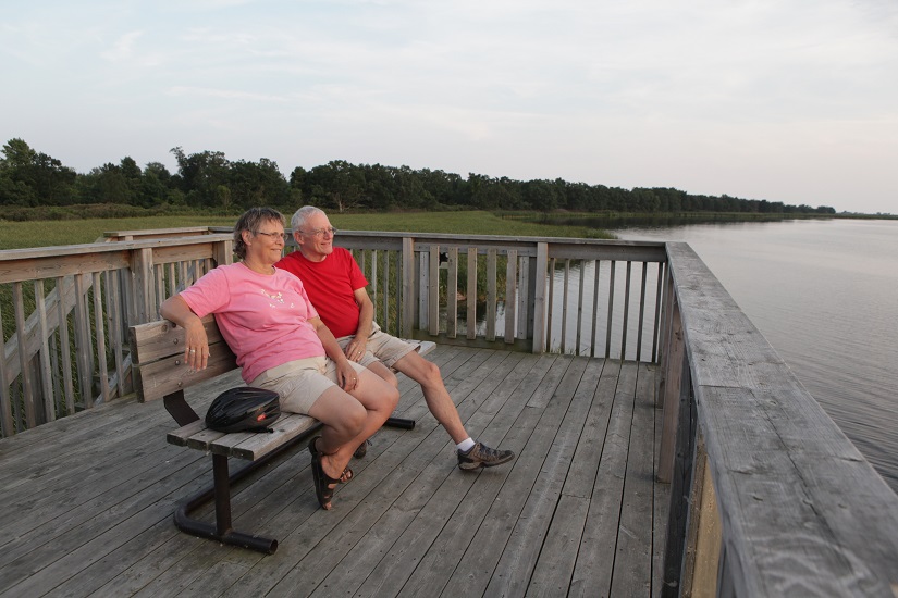 Senior couple sits on bench at lookout tower