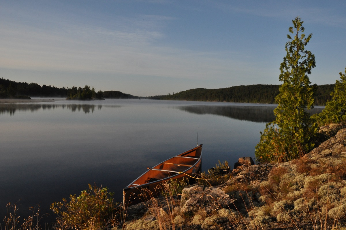 Canoe on a still lake at dusk
