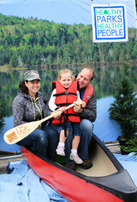 Family in fake canoe in front of backdrop
