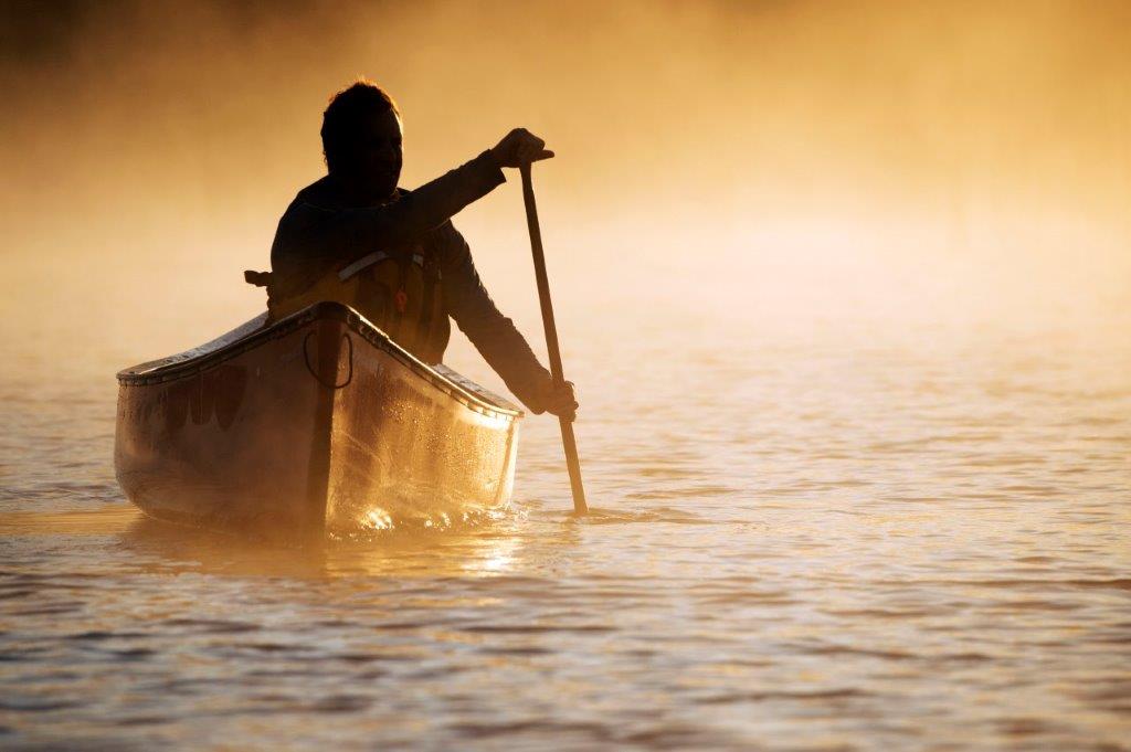 La silhouette d’un pagayeur sur un lac brumeux