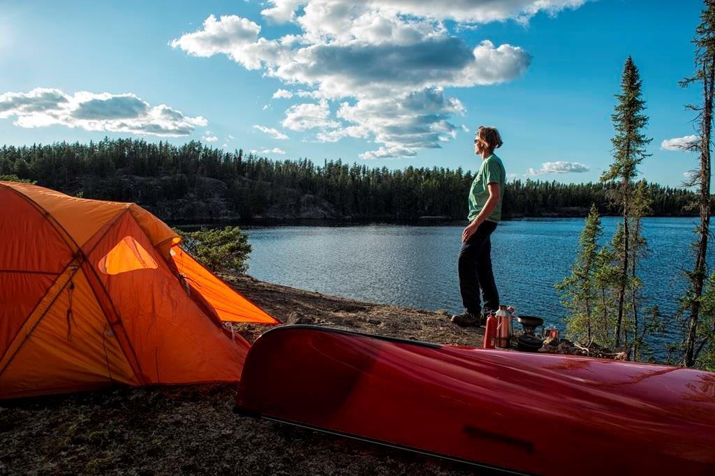 Une personne admirant la vue du lac et de la forêt à partir de son emplacement de camping 