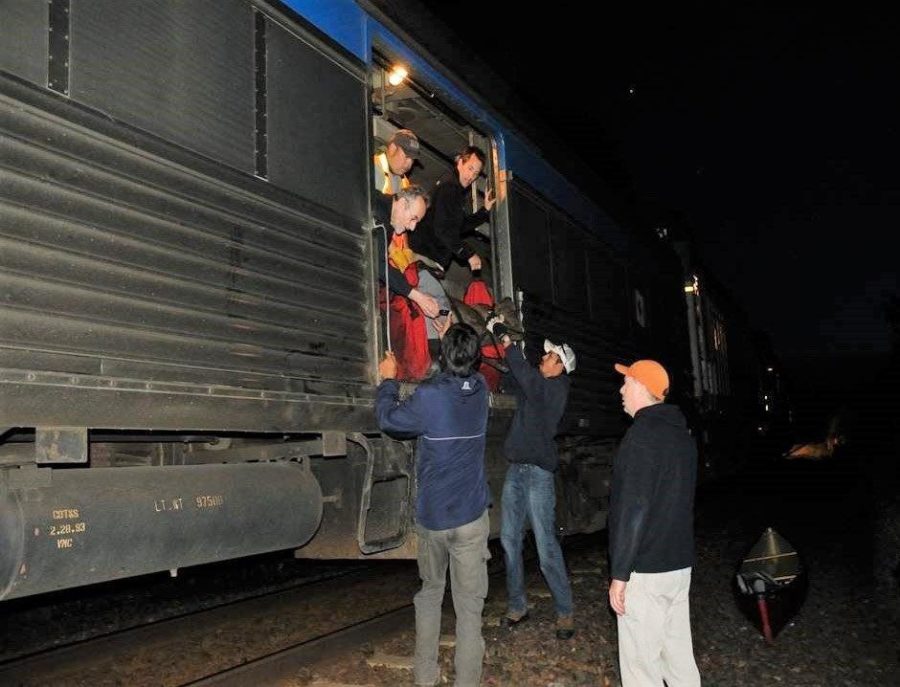 Paddlers loading up a train at night
