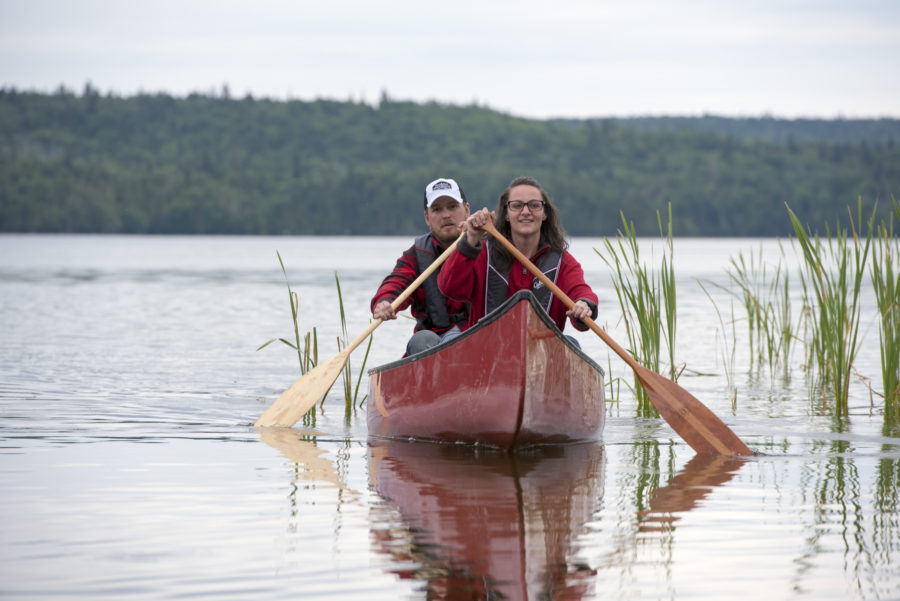 Head on shot of two people canoeing on the lake