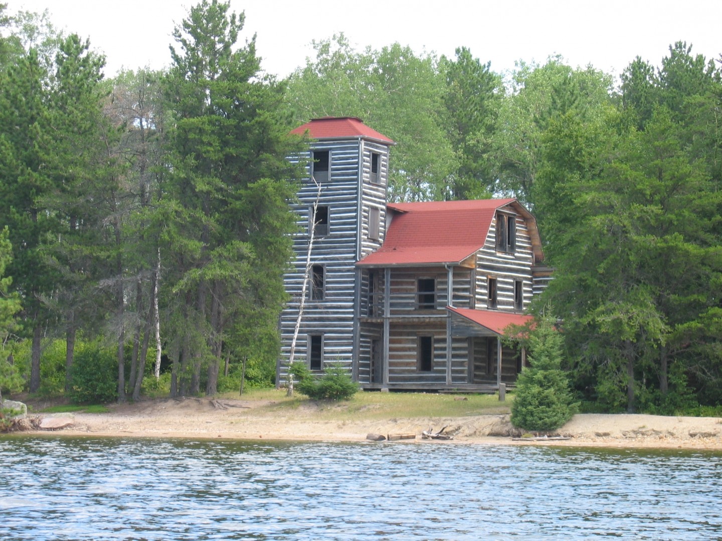 Log structure on shore of a lake with a tall tower
