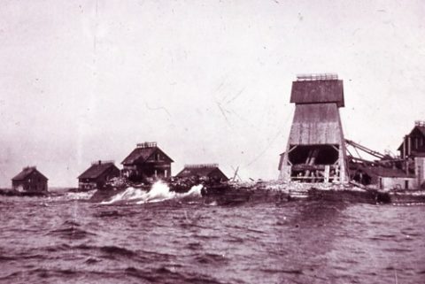 Black and white photo of small island with a variety of mining operation buildings