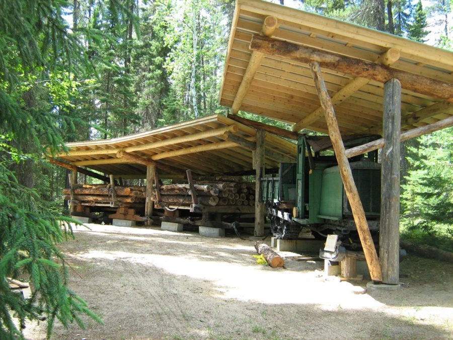 Structure de bois recouvrant un ancien tracteur conçu pour convoyer des rondins.