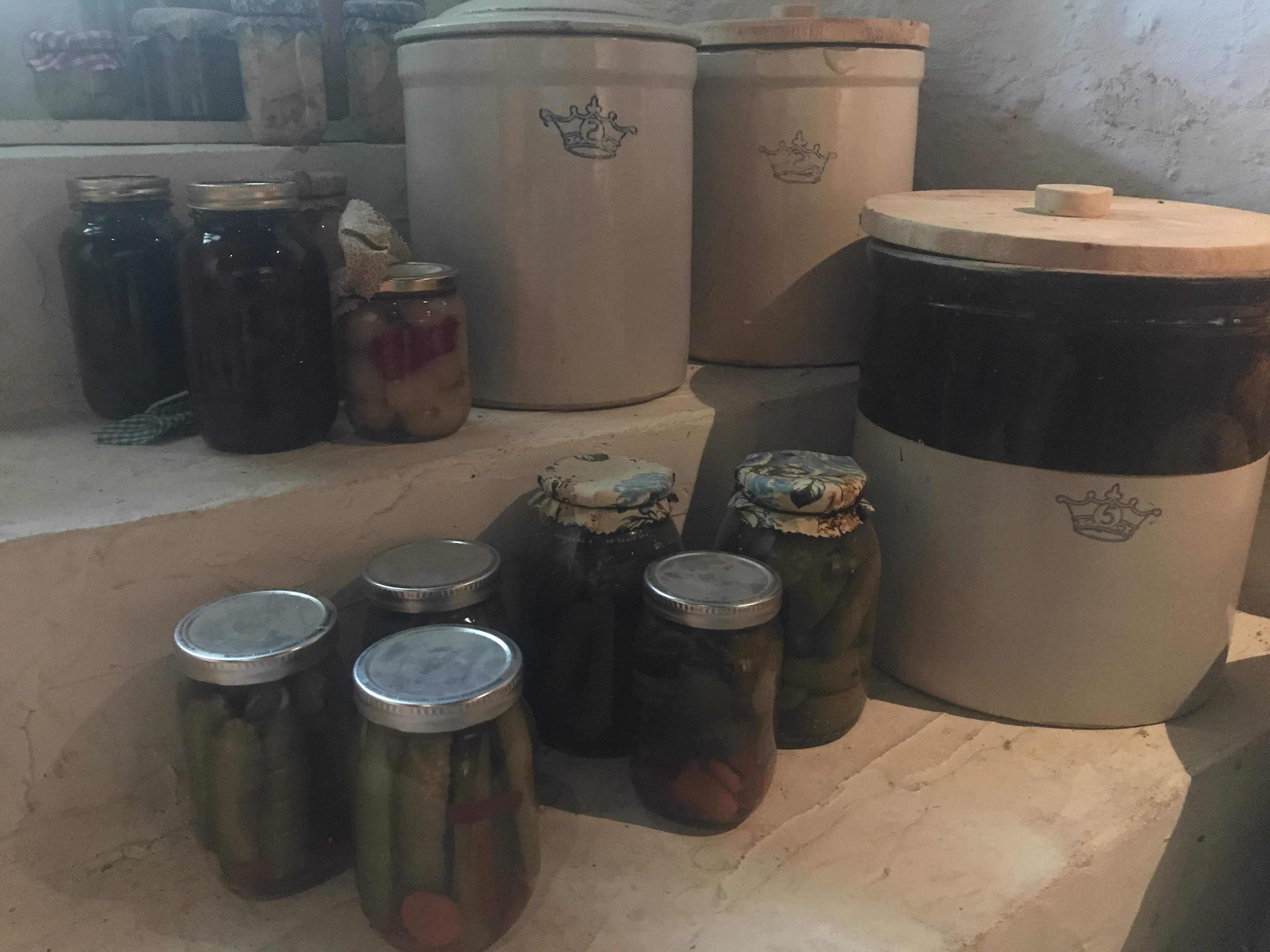 Preserves sitting in front of a group of crocks