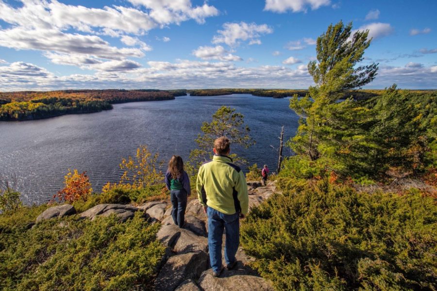 Two people look out on to the lake in the fall
