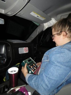 Person sitting in the passenger seat of a truck with an instrument